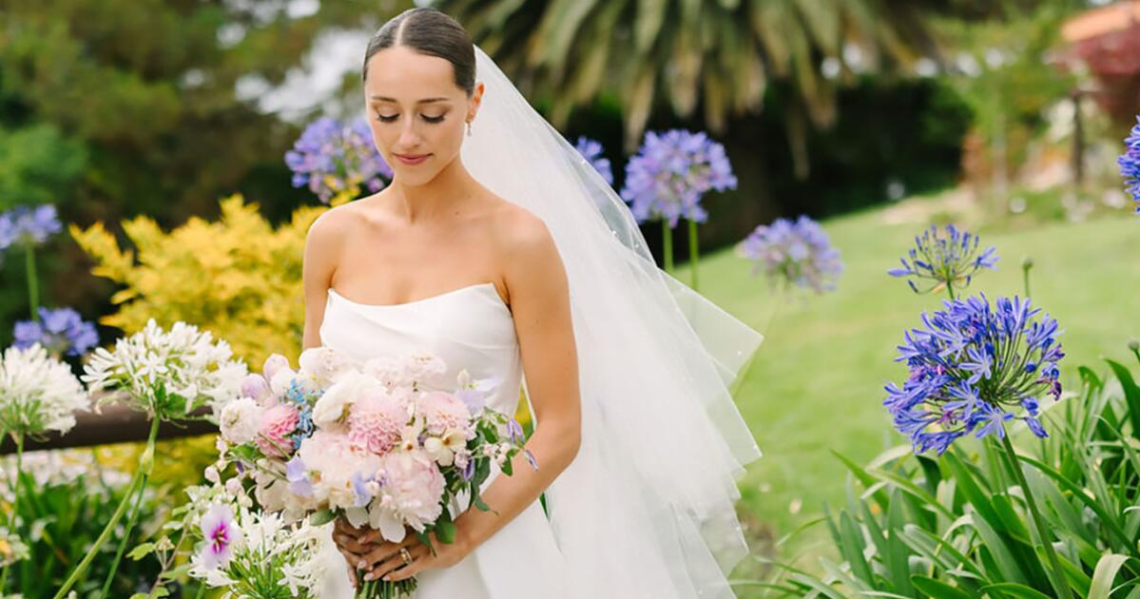 A beautiful bride wearing elegant 2026 bridal makeup with glowing skin, soft eye makeup, nude lips, and a stylish wedding hairstyle.